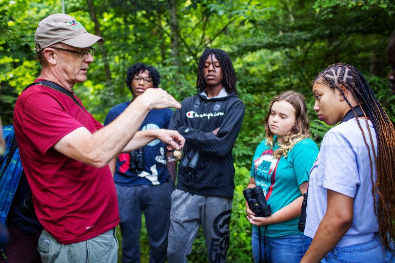 A professor discusses birds with students. 