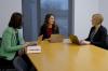 A photo showing three professors collaborating around a table. 