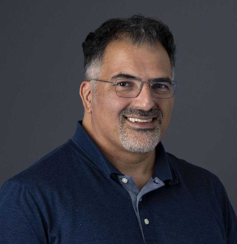 A self photo of Dr. Afshin Beheshti in a navy blue collared button up shirt.